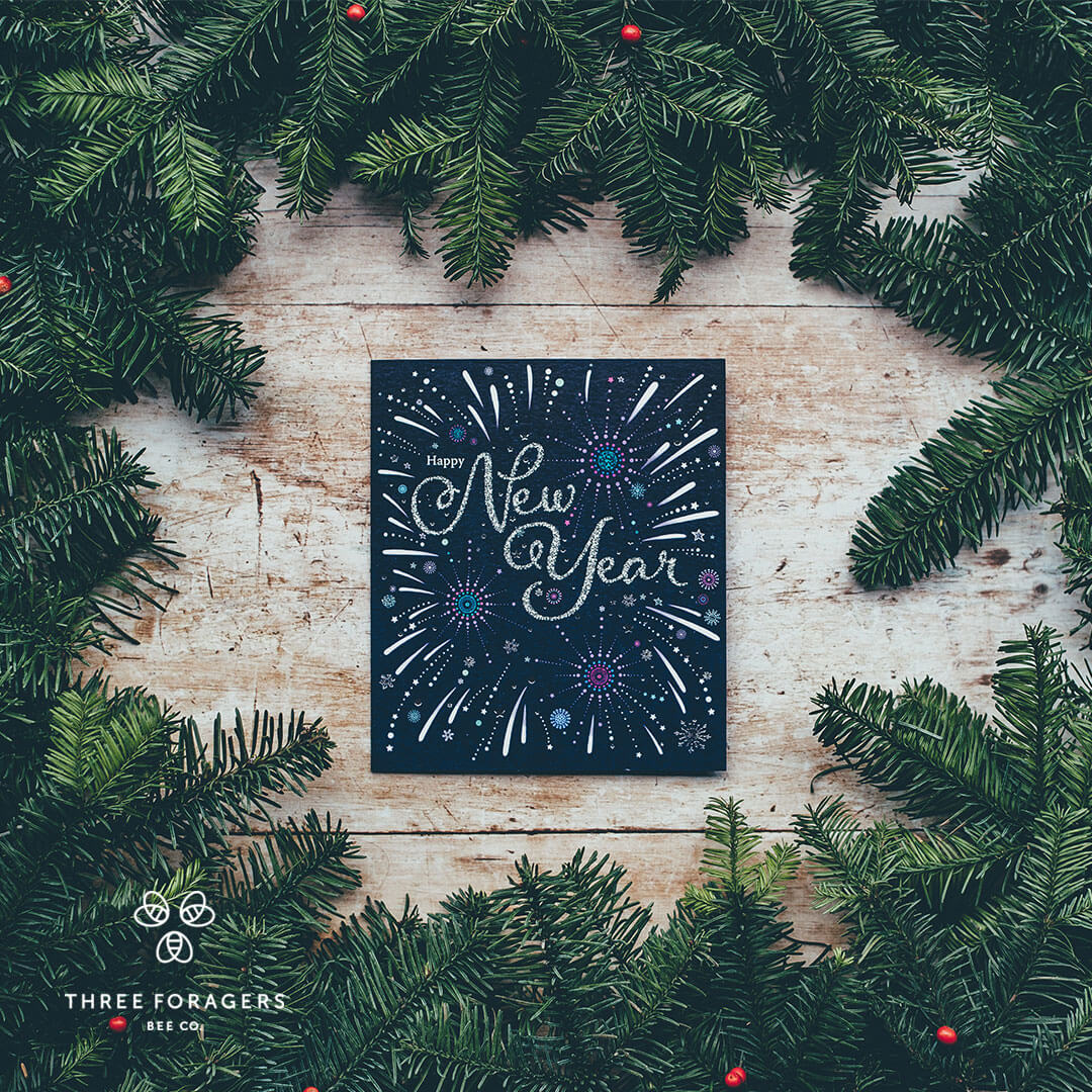 A plaque saying Happy New Year amid a bunch of pine branches